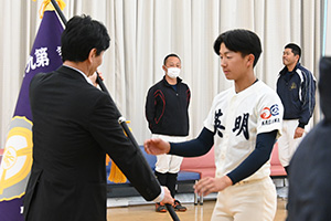 校長から旗を受け取る主将